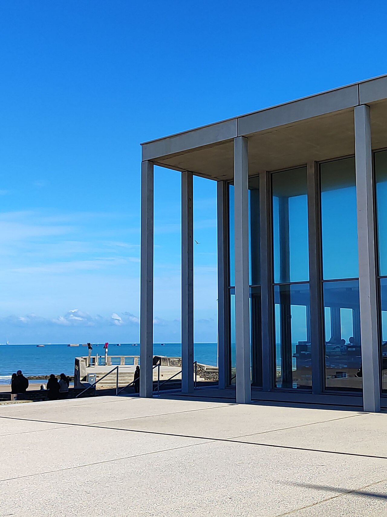 La façade vitrée du musée du Débarquement à Arromanches, photographiée en 2026.